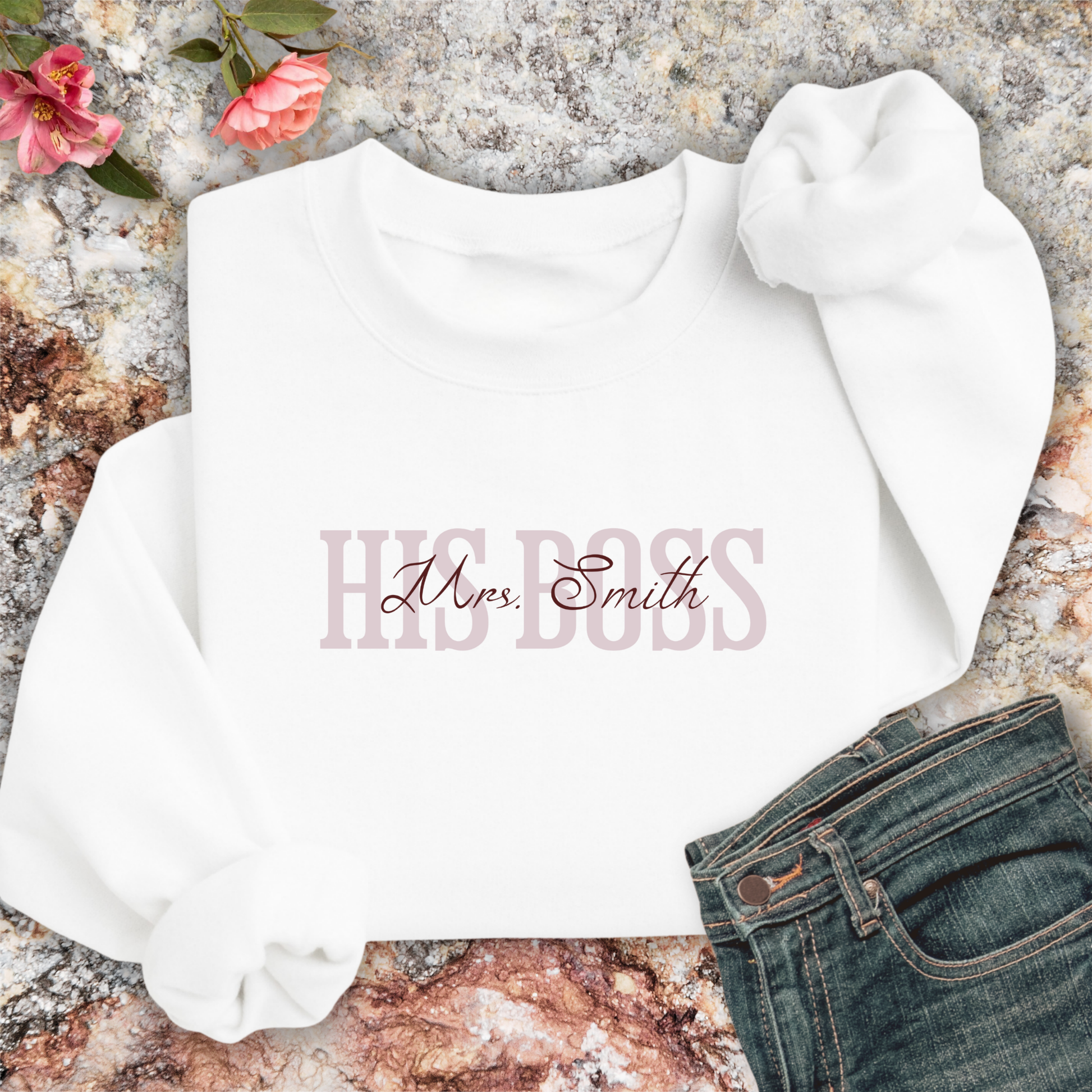 White sweatshirt with 'HIS BOSS Mrs. Smith' text on a marble surface.